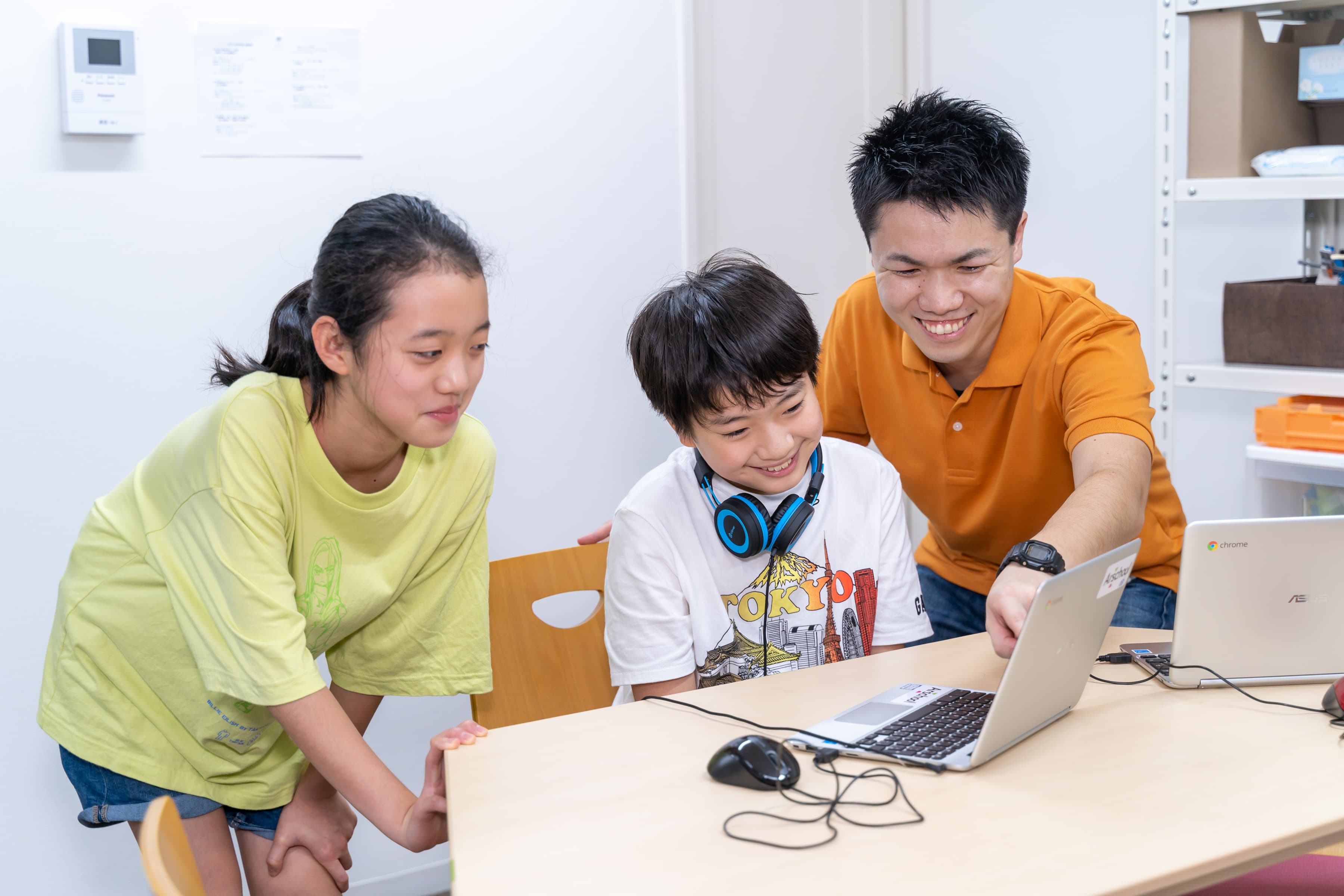 教室で子どもたちが講師と一緒にアルスタジオVを使って制作している様子