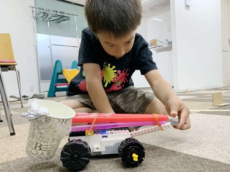 自分で組み立てたレゴ®の車を動かす子ども